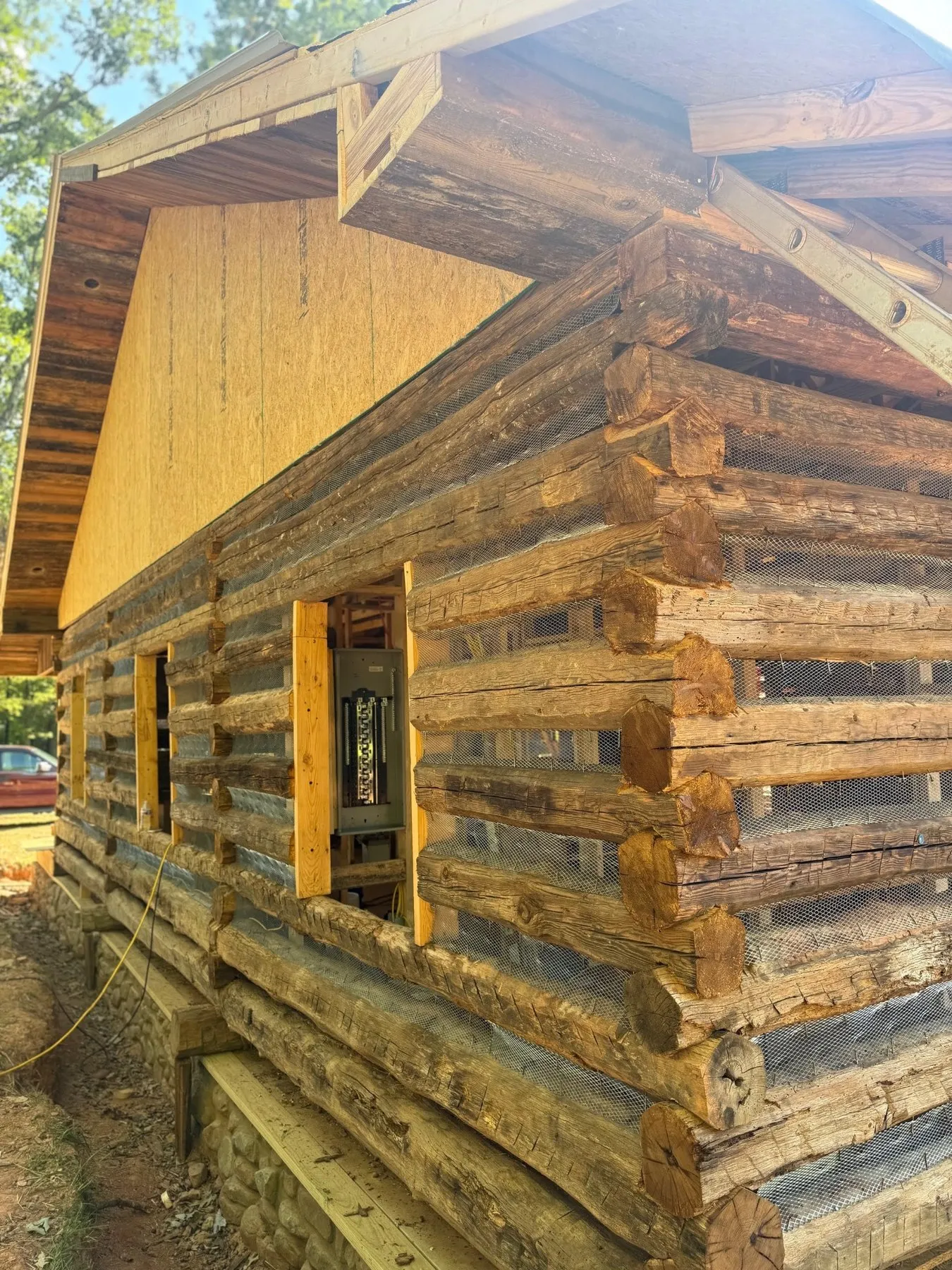 New breaker panel set between the logs of a cabin under construction
